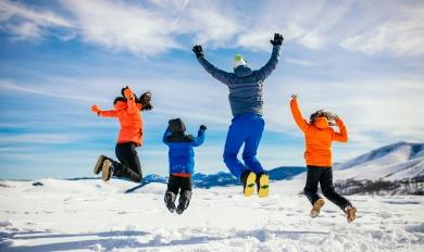 famille heureuse qui saute dans la neige 