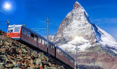 Train suisse sous massif enneigé 